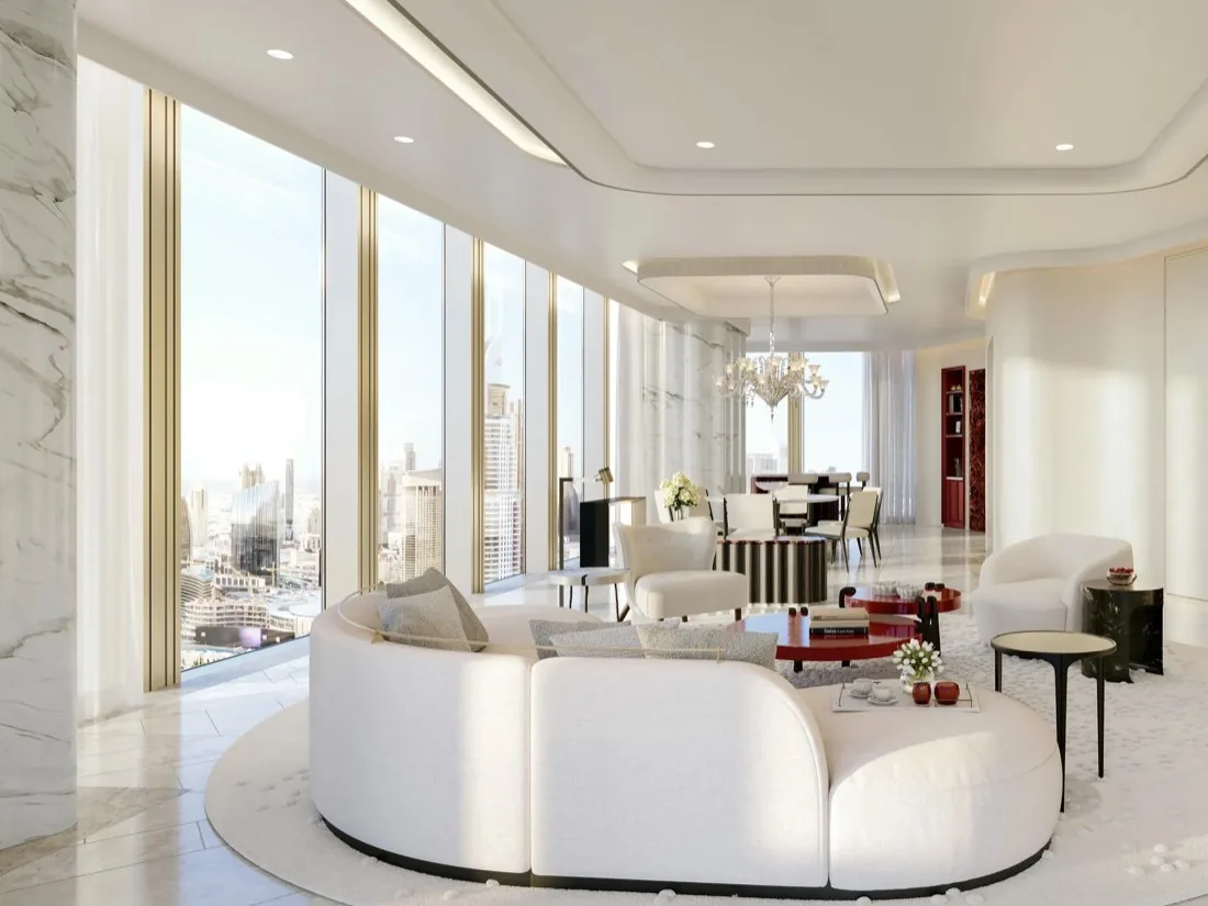 Living room with a curved white sofa, floor-to-ceiling windows over Downtown Dubai and a dining area beyond, Baccarat Residences