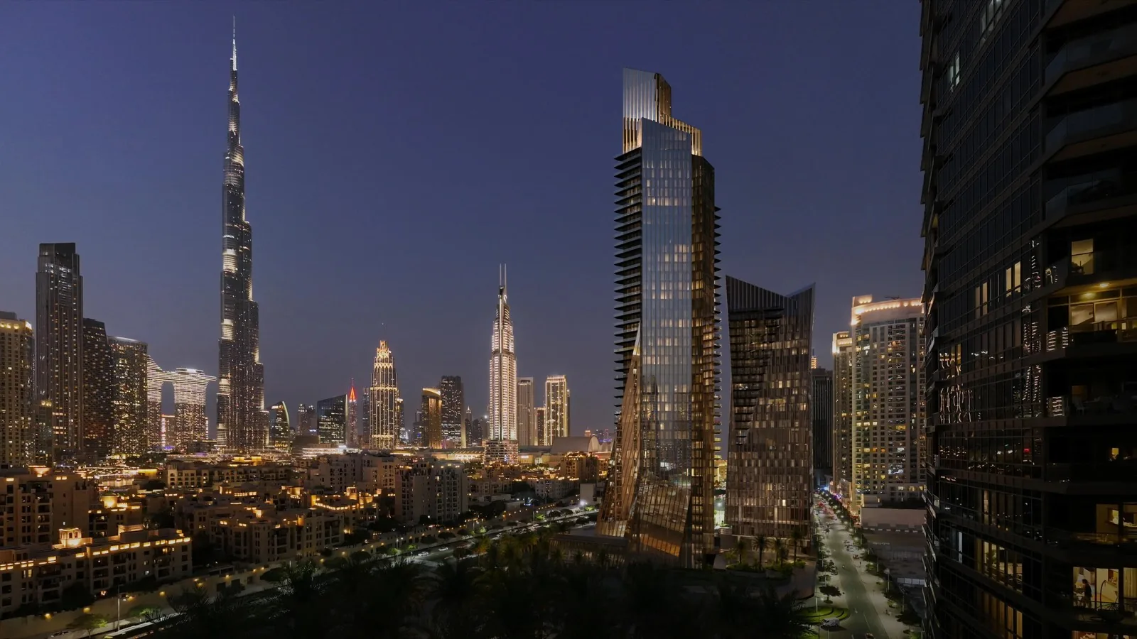 Baccarat Hotel & Residences towers beside the Burj Khalifa on the Downtown Dubai skyline at dusk