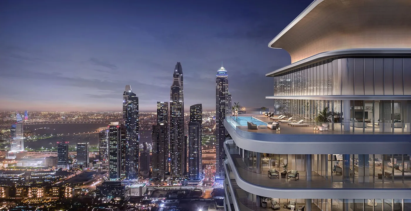 Bayview rooftop pool terrace with sun loungers above the Dubai Marina skyline at night