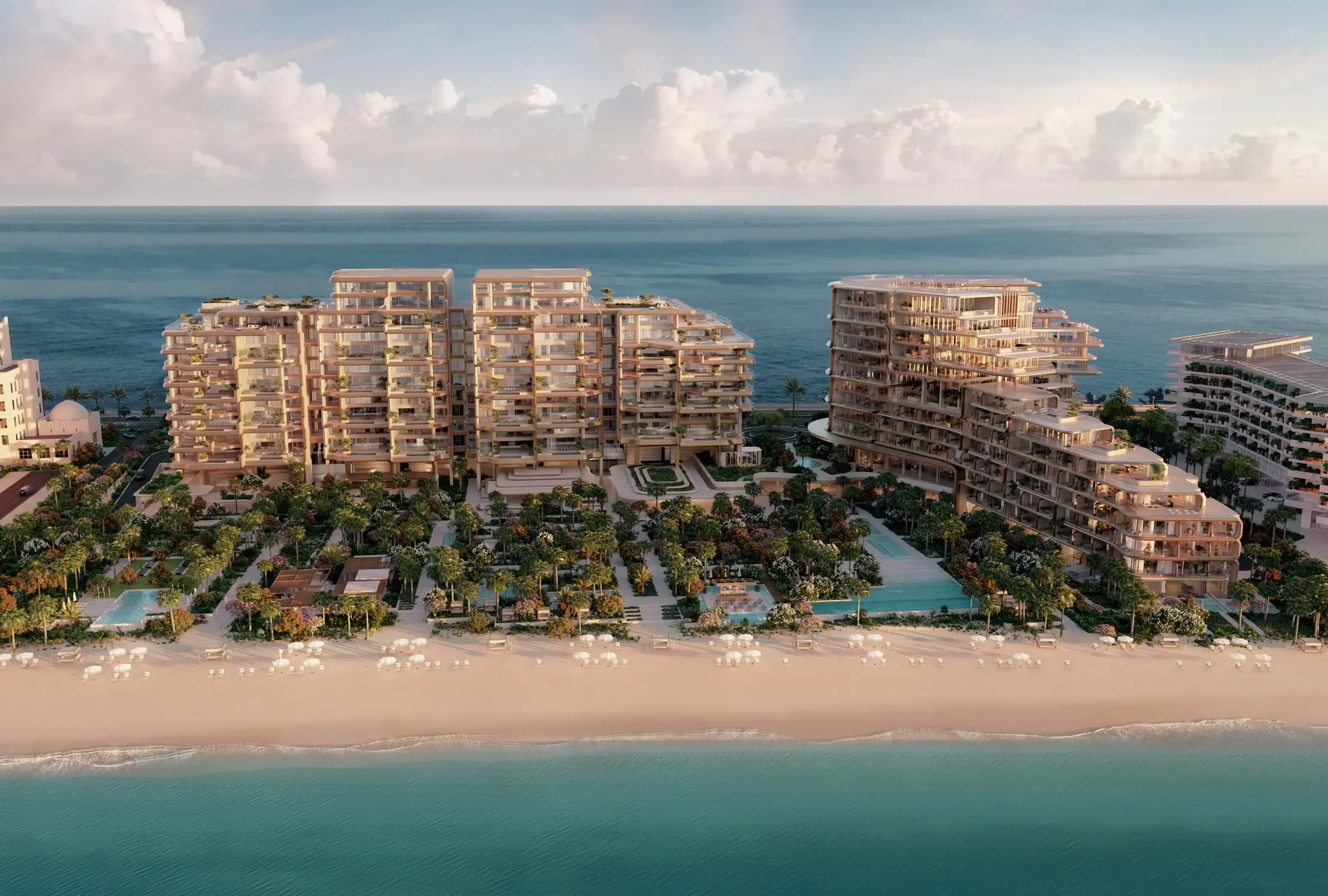 Aerial view of The Alba Residences terraced buildings behind the beach and gardens on Palm Jumeirah