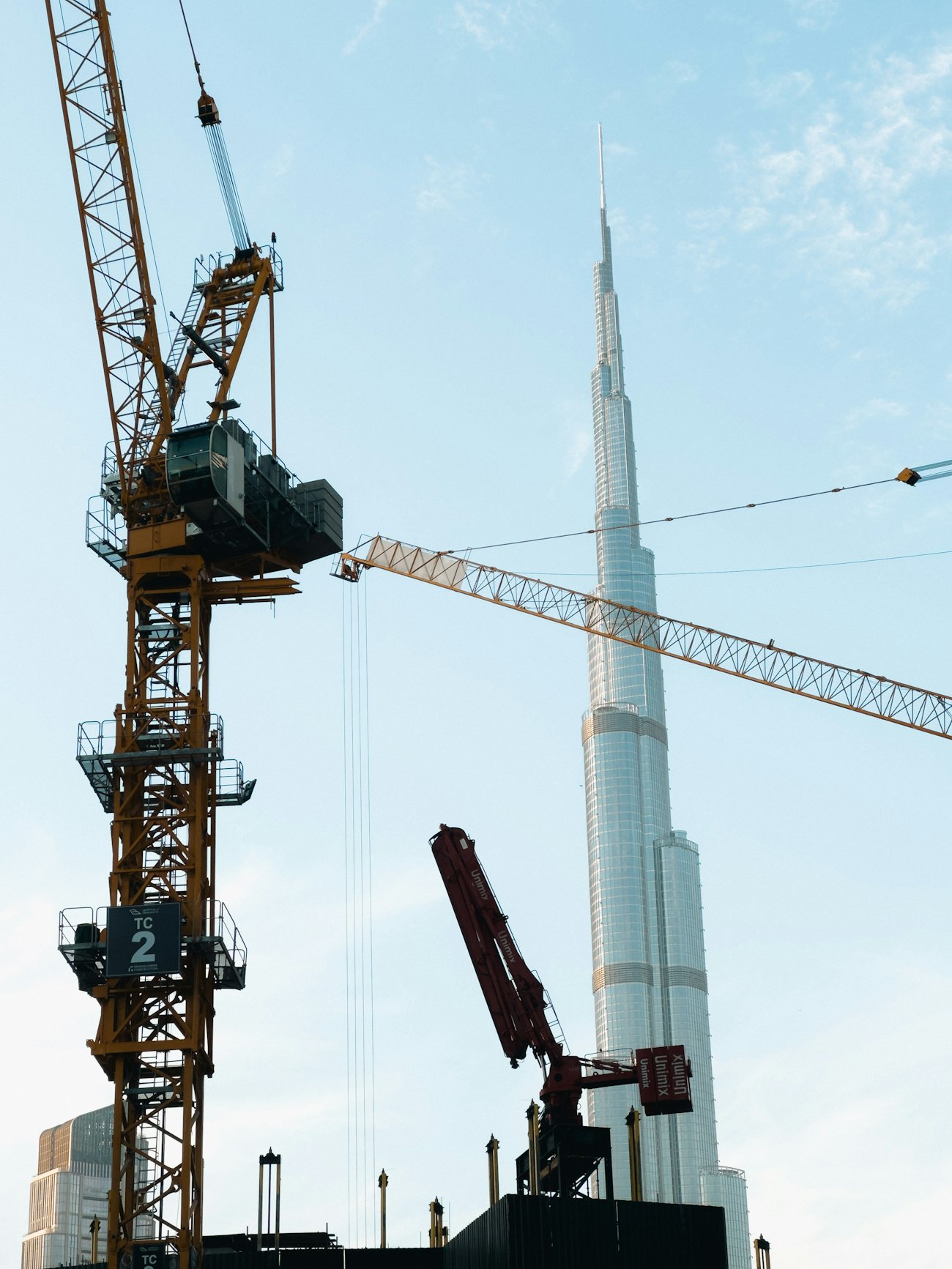 Construction cranes beside Burj Khalifa - Dubai off-plan property boom