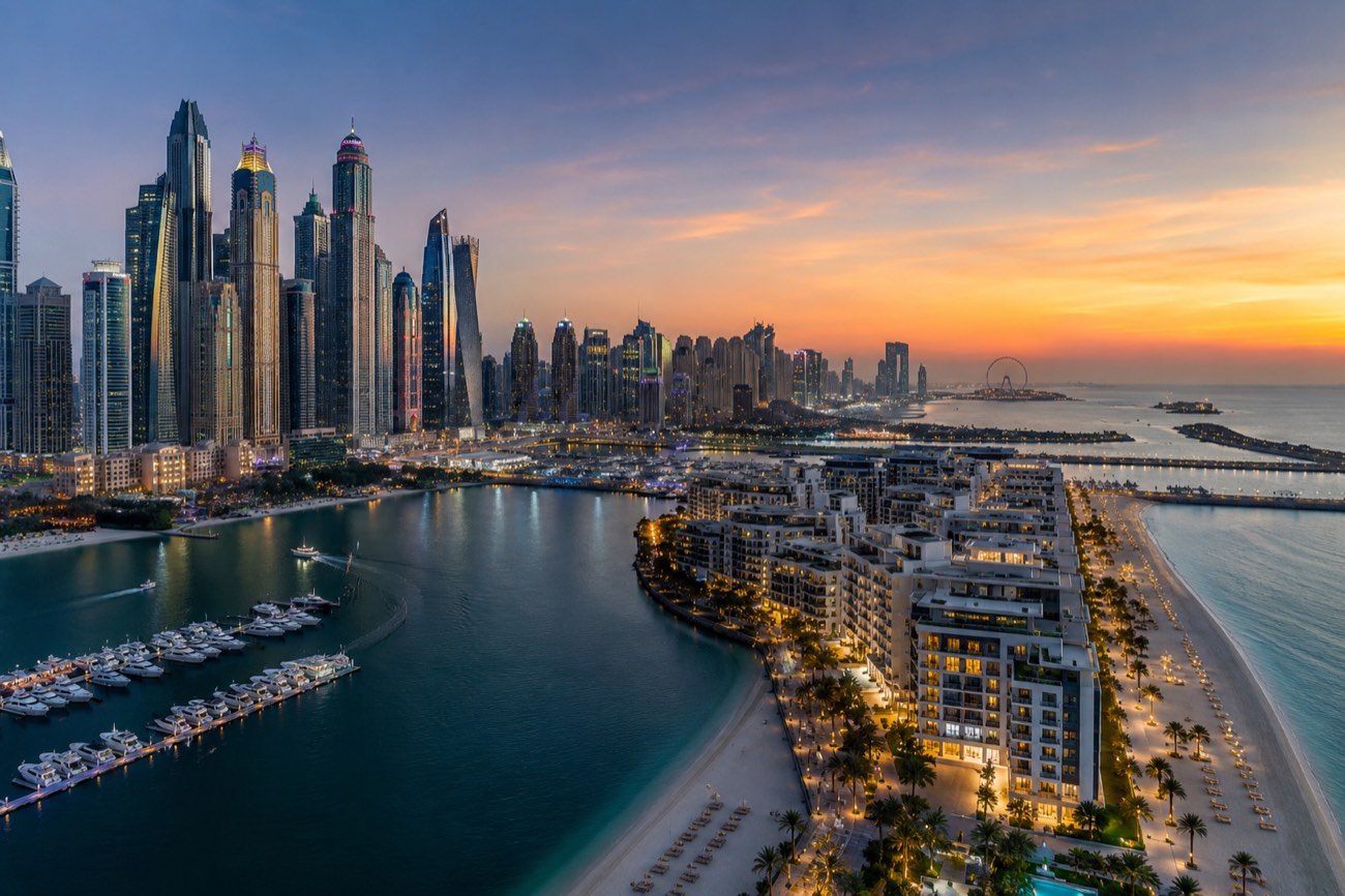 Dubai Marina skyline and Palm Jumeirah beachfront apartments at sunset - waterfront freehold areas for foreigners
