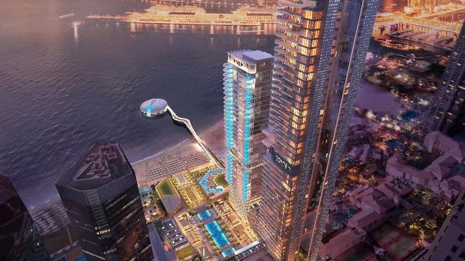 Aerial view of the FIVE LUXE development on the JBR beachfront at dusk with the Sensoria tower, the beach pools and Palm Jumeirah across the water - developer render courtesy of FIVE Holdings